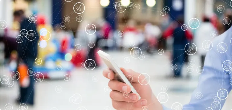 Une personne consulte son smartphone dans une rue animée