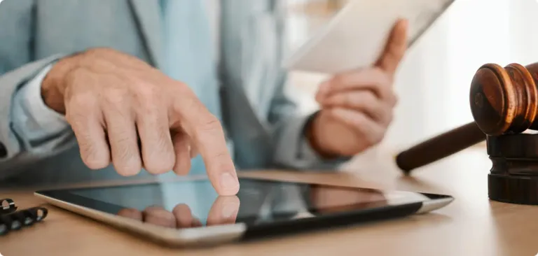Un maillet de juge posé à côté d'une tablette