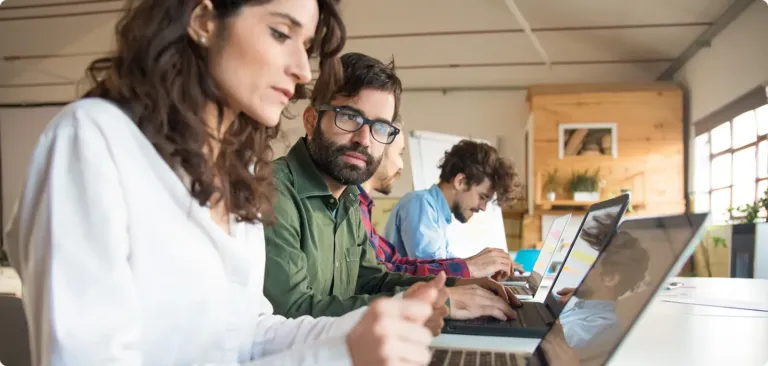 Une équipe concentrée travaille sur des ordinateurs portables